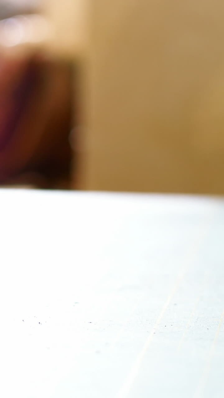 Mid-section of craftswoman rolling up the sheet of leather on work tool
