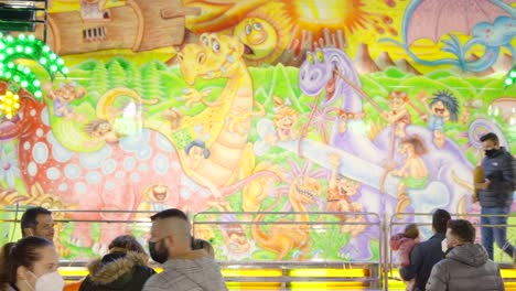 people on a dinosaur-themed carousel at a fair