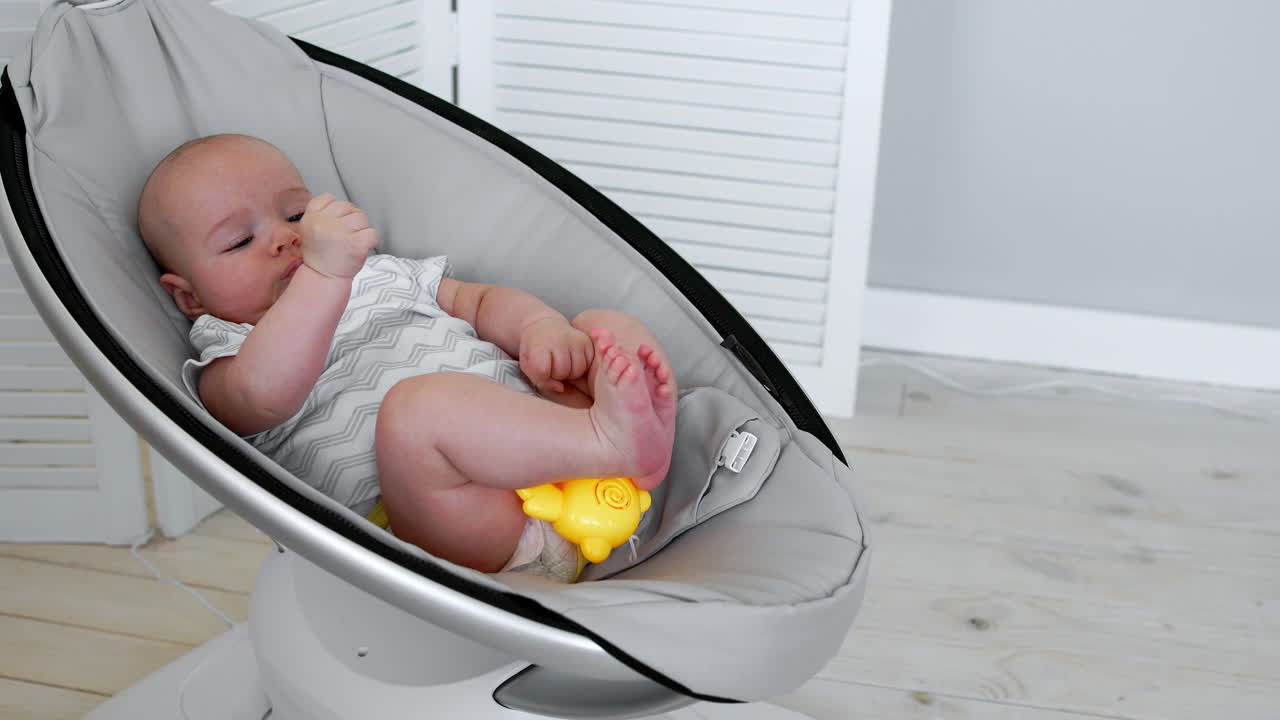 Modern high-tech rocking chair helps parents put the child to bed. White interior of children's room