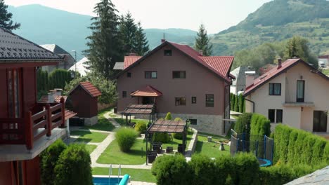 modern houses with garden landscape and swimming pool on a sunny day - aerial