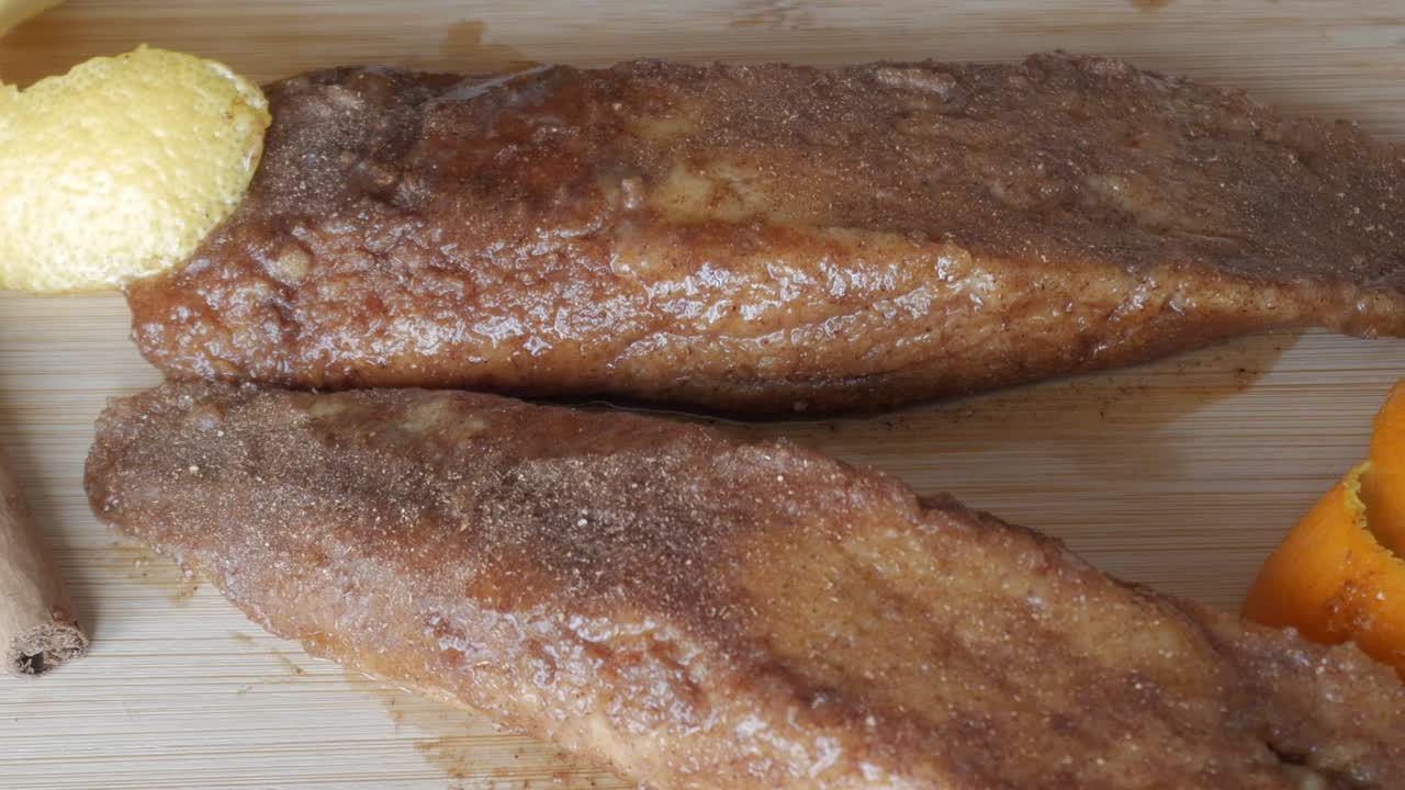 Sweet Torrijas with a cinnamon stick and lemon zest, a traditional Spanish treat