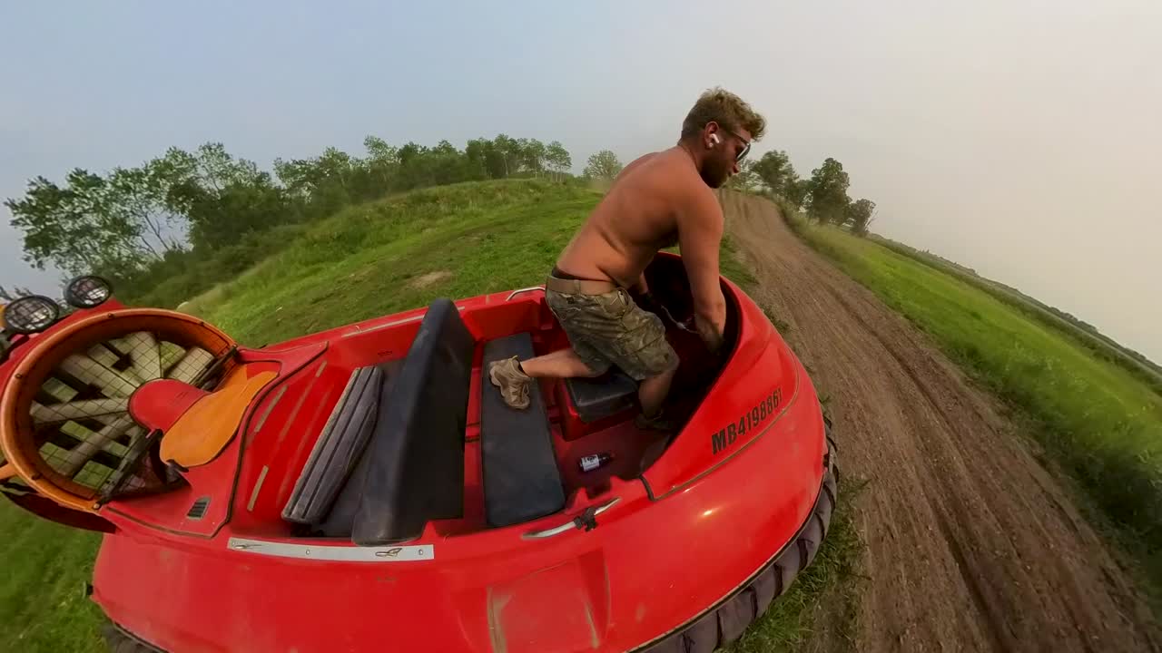 vista de cámara de 360 de un hombre que opera una embarcación flotante a través de un campo de hierba