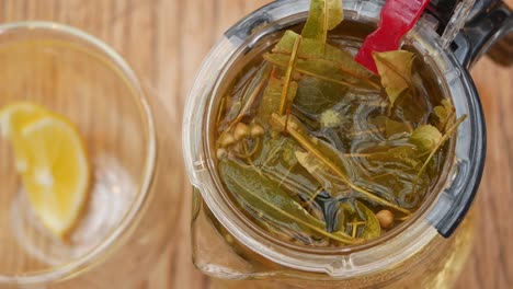 a glass of herbal tea with lemon wedge