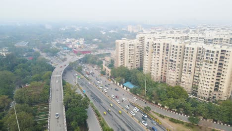aerial drone shot highlighting the busy delhi traffic on a flyover during peak hours, as vehicles fill every lane.