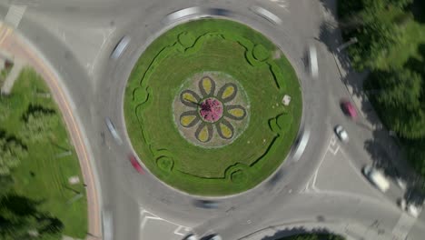 aerial view timelapse of roundabout road with circular cars in small european city at sunny summer day