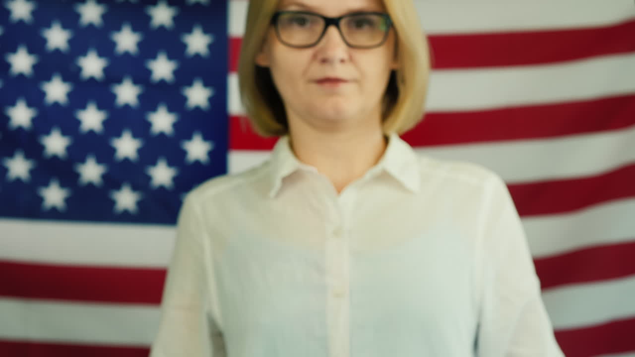 젊은 여성은 인종차별이 미국 국기 배경에 유행병이라는 포스터를 들고 있습니다.