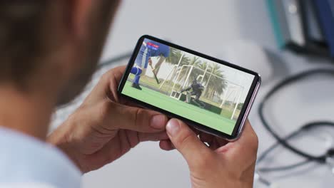 Composite-of-male-doctor-watching-hockey-match-on-smartphone