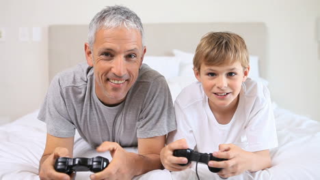 padre y hijo felices jugando videojuegos