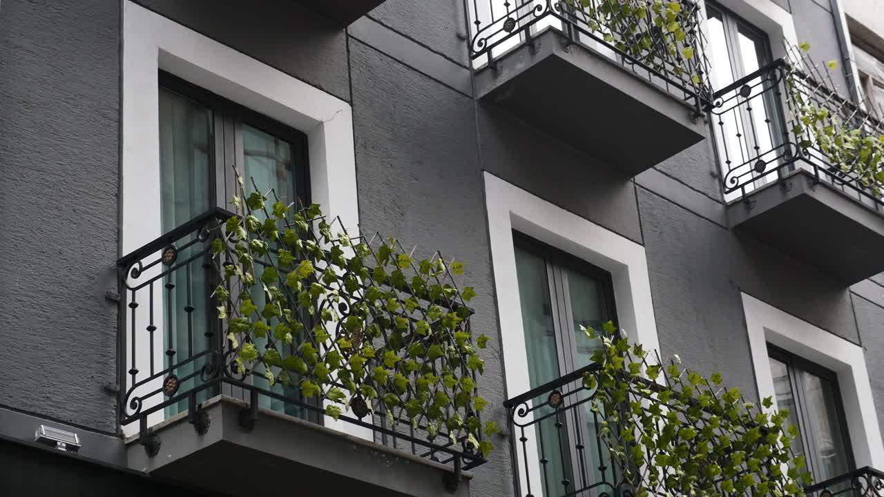 primer plano de un edificio moderno con balcones y plantas verdes