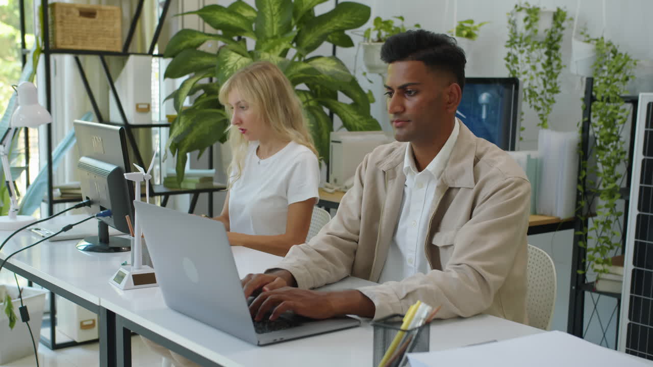 Team of Ecology Engineers Using Digital Devices at Green Office