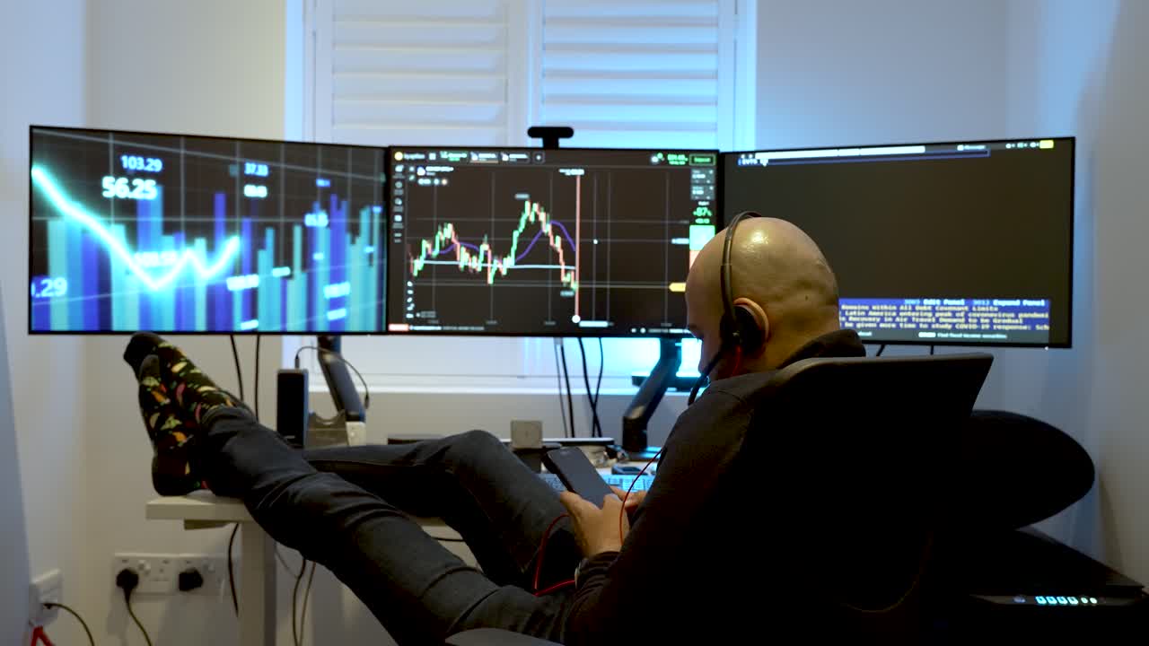 A man sits comfortably in front of three interconnected computer screens, representing the idea of engaging in home-based or day-trading activities