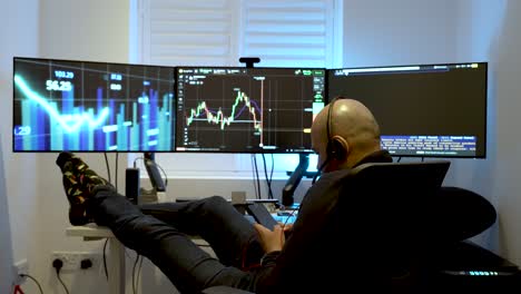 a man sits comfortably in front of three interconnected computer screens, representing the idea of engaging in home-based or day-trading activities