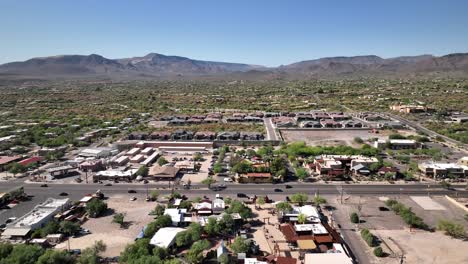 Cars-driving-down-the-main-strip-of-Cave-Creek,-Arizona-in-the-middle-of-the-day