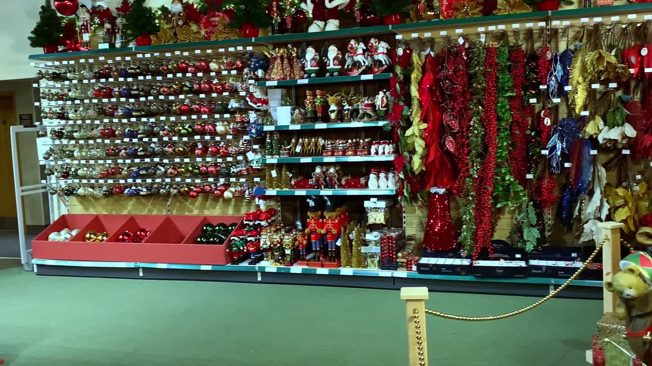 estantes llenos de oropeles, bolas, decoraciones de árboles con un modelo de santa claus de tamaño completo también en la tienda de navidad del centro de jardinería del condado de leicestershire