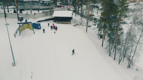 un grupo de personas observa al snowboarder descender por una pendiente nevada.