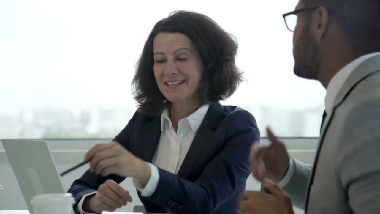 Duas pessoas de negócios sorridentes conversando durante a reunião