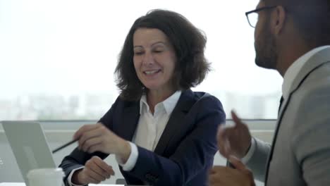 two smiling business people talking during meeting