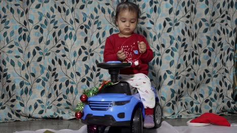 cute-infant-enjoying-Christmas-eve-celebration-with-kid-car-gift-at-home-at-night