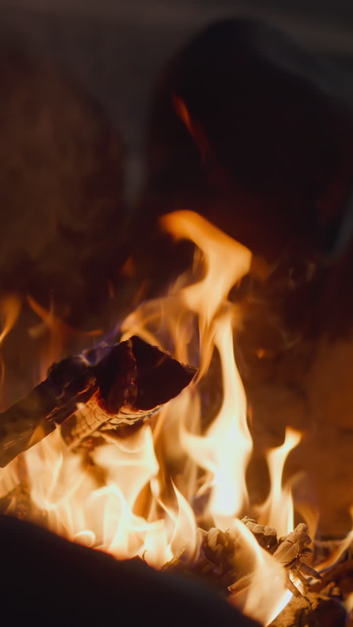 Fire burns in special bowl at night closeup slow motion. Fireplace with burning woods in courtyard. Decor and warming place to rest
