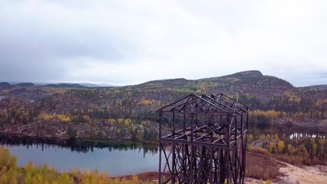 aerial downward pedestal of an abandoned mine headframe in the boreal forest in fall