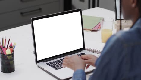 Composition-of-african-american-schoolgirl-on-laptop-online-learning-with-blank-screen