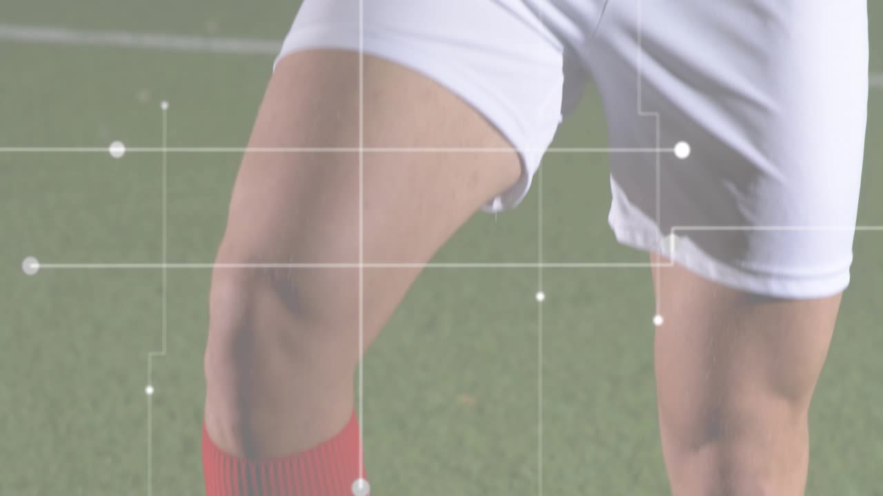 Panning della telecamera da gambe con pantaloncini bianchi sull'erba a un volto di un giocatore concentrato, che mostra i dati sulle prestazioni