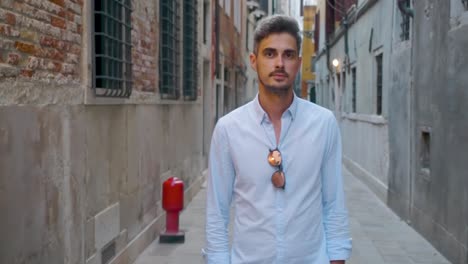 man standing in a narrow urban alleyway