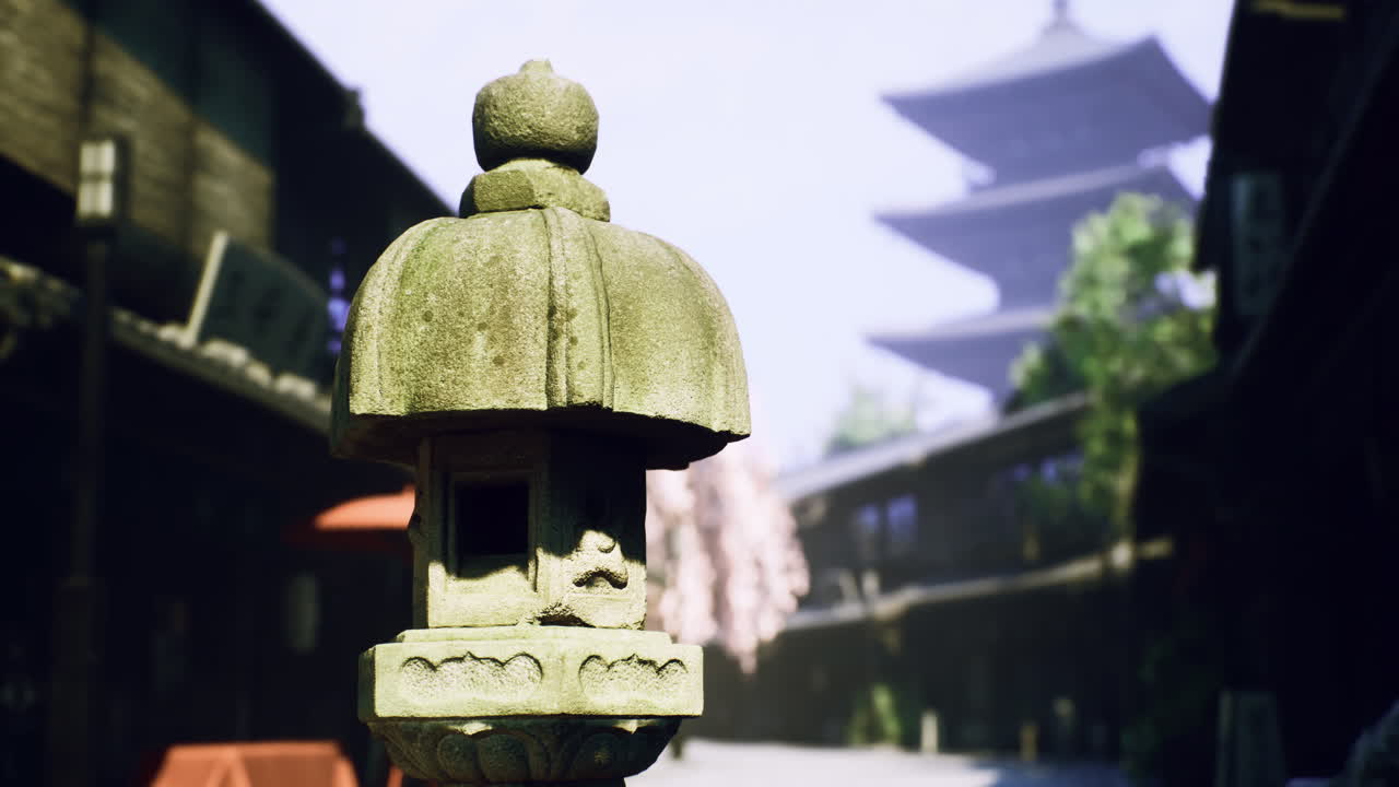 Ancient lantern stands in quiet street with pagoda in background during daytime