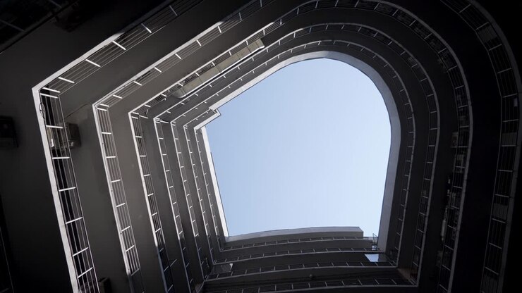 A bottom perspective of rounded shaped building. Real estate. Modern building construction. External view. architecture scene. Spiraling structure. Swirling up to sky