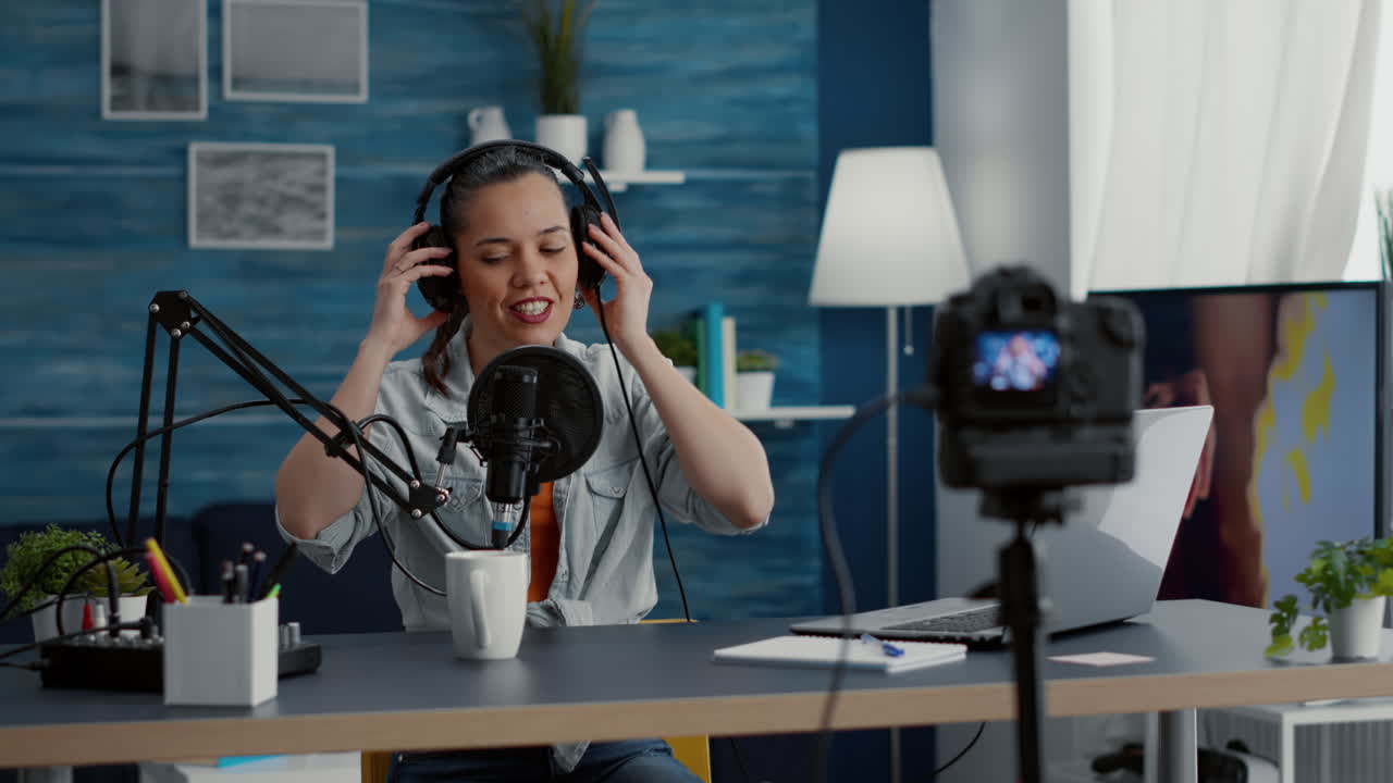 Social media influencer putting headphones on while filming vlog