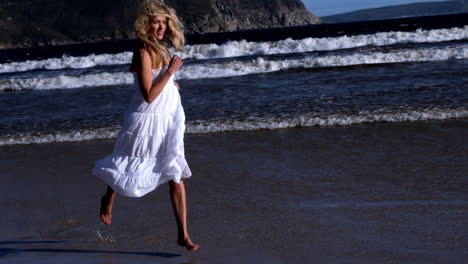 Schöne-Blondine-Läuft-Im-Weißen-Kleid-An-Einem-Sonnigen-Tag-Am-Strand