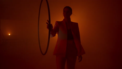 woman in a suit performing with an aerial hoop