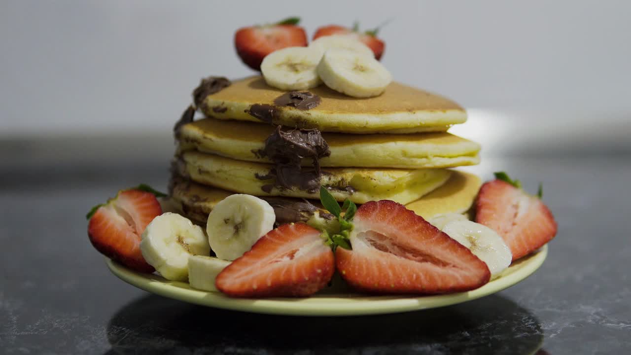 주방에 딸기와 바나나가 있는 아메리칸 팬케이크