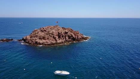 volando alrededor de una isla rocosa en el mar mediterráneo