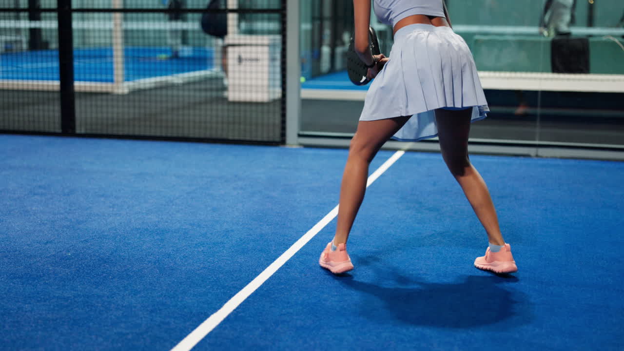 Woman playing padel tennis indoors