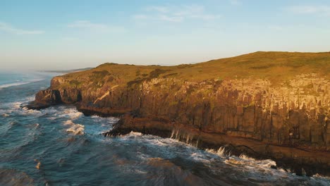 rocky cliffs on atlantic ocean at sunrise drone point of view