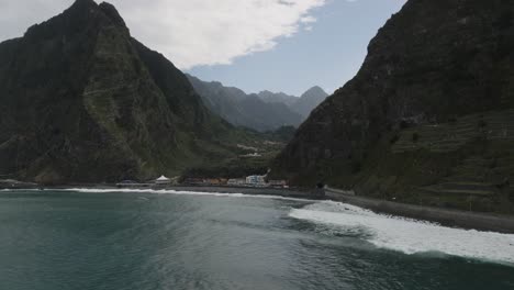 Drone-shot-of-a-beautiful-beach-next-to-mountains