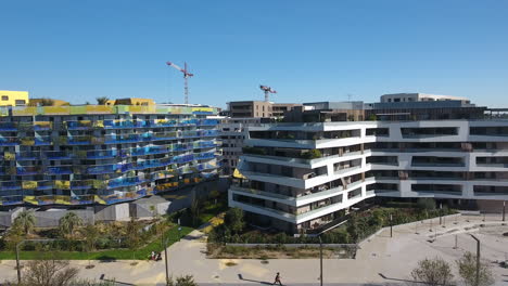 Seitliche-Drohnenaufnahme-Moderner-Öko-Gebäude-Im-Hafen-Von-Montpellier,-Marianne.-Antenne