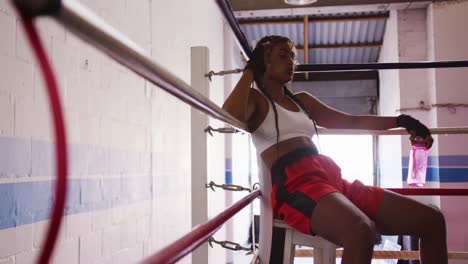 Mujer-De-Raza-Mixta-Descansando-En-El-Gimnasio-De-Boxeo.