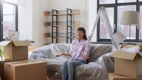 Women-with-Box-and-Foam-Peanut-Moving-to-New-Home.moving,-people-and-real-estate-concept--women-unpacking-boxes,-throwing-foam-peanuts-and-having-fun-at-new-home