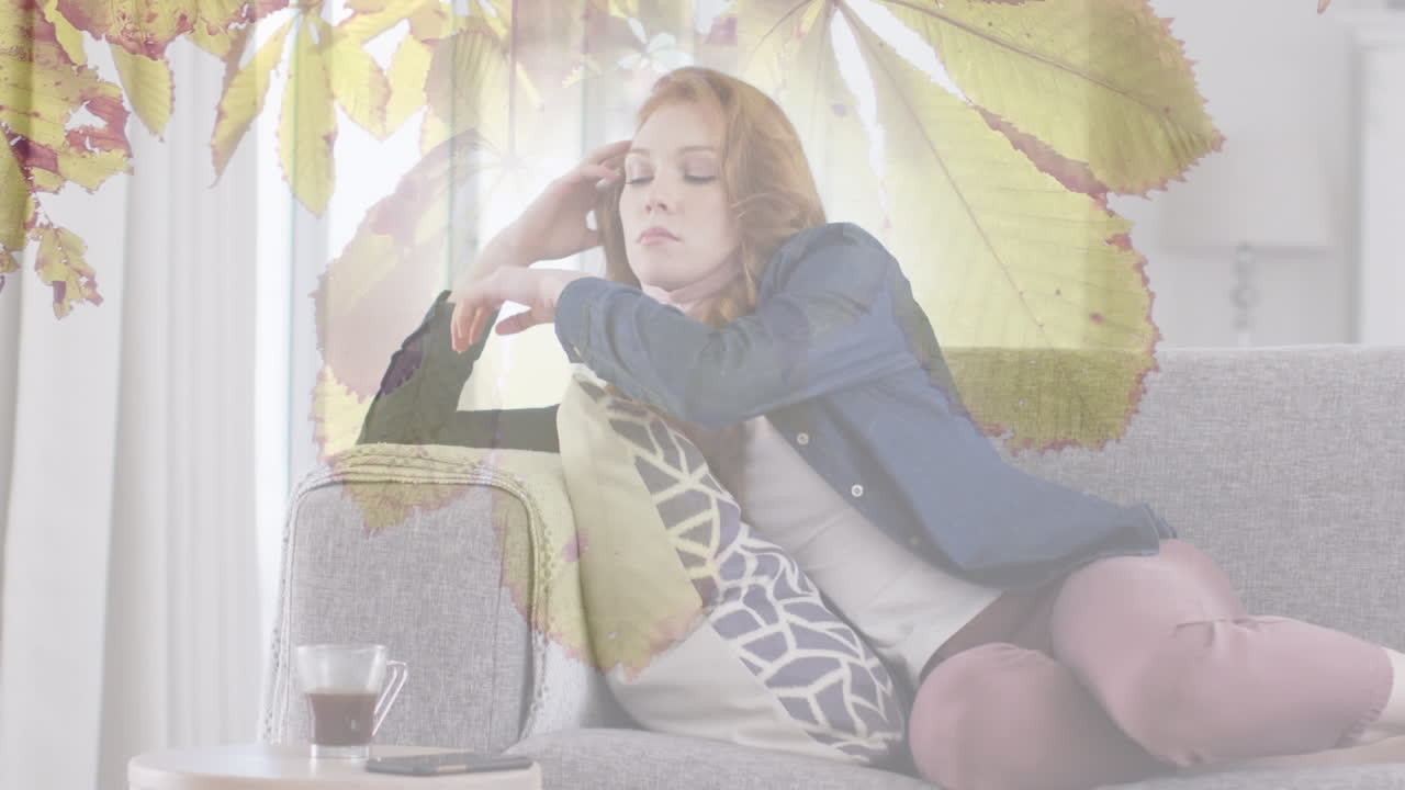 소파에 앉아있는 백인 여성 위에 가을 잎의 애니메이션