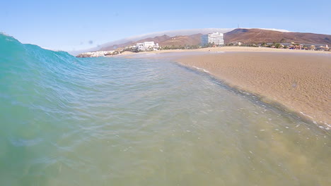 Cerca-De-Las-Olas-Del-Océano-Rodando-Y-Salpicando-En-La-Costa-Arenosa-En-Fuerteventura,-Islas-Canarias,-España