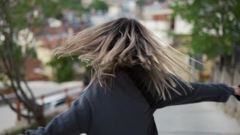 excited, happy woman spinning around enjoying her walk during vacation outdoors