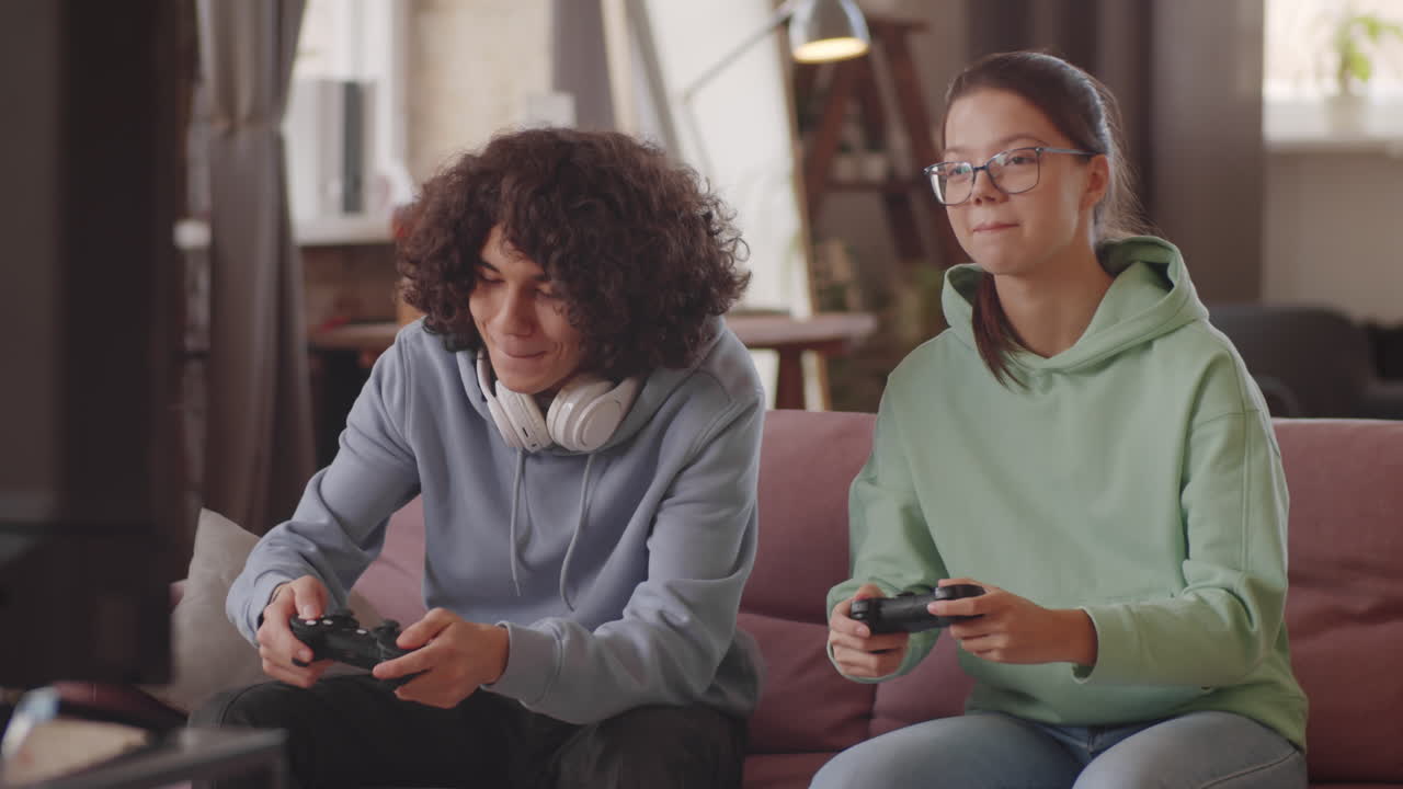 Teen Kids Playing Video Game on Console at Home