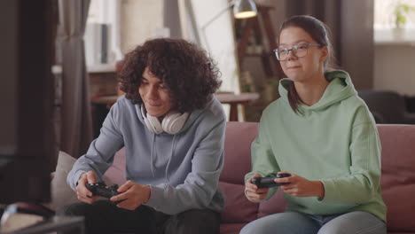 teen kids playing video game on console at home