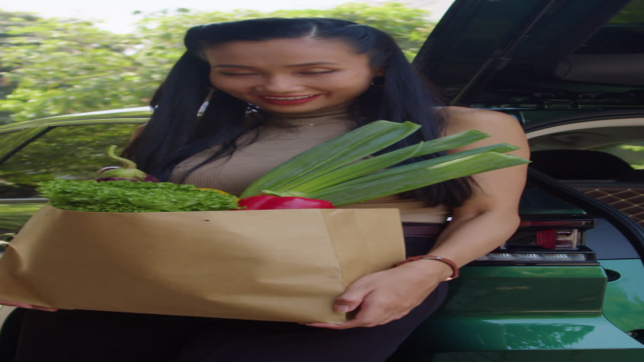 Portrait of Woman Holding Bag of Groceries after Shopping by Car