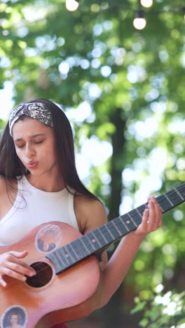 teenage girl singing and playing acoustic guitar outdoors