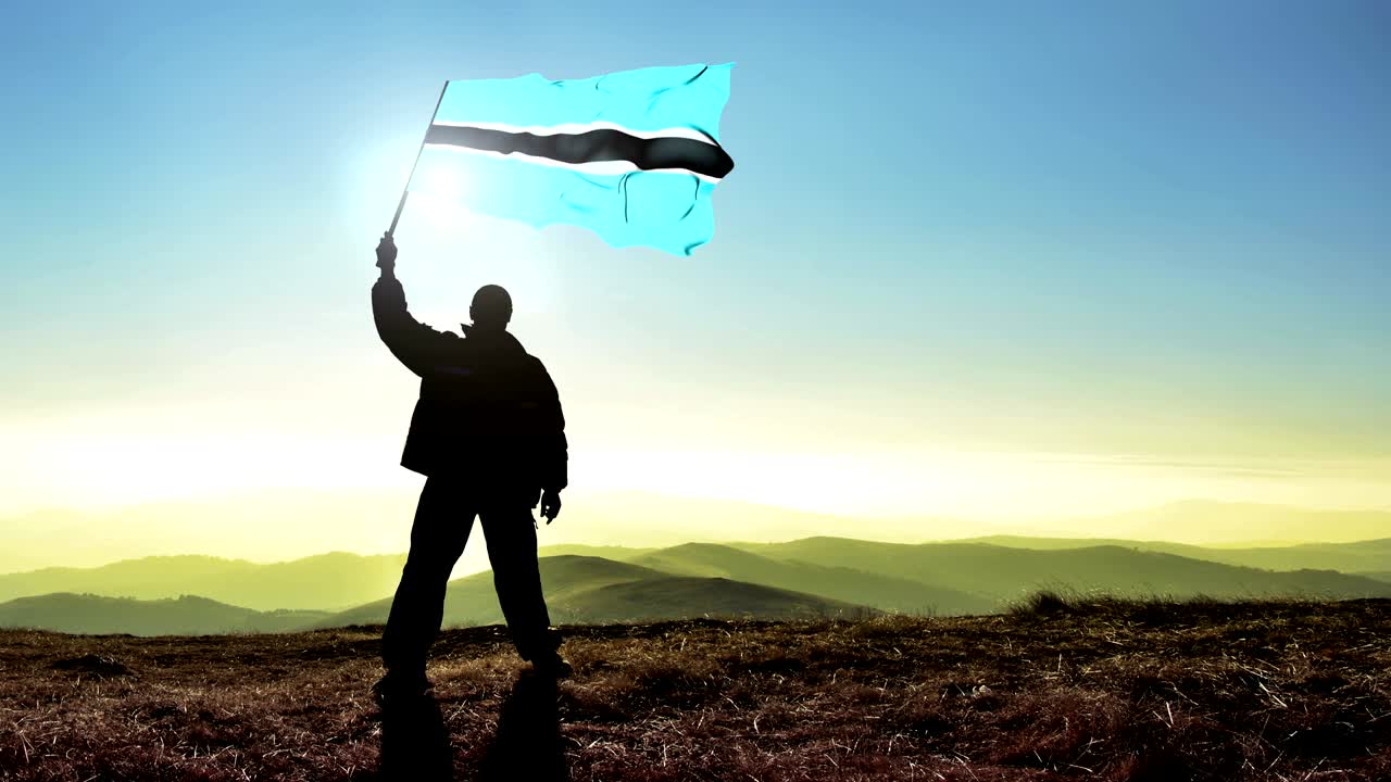 산꼭대기 위에서 보츠와나 발을 흔들고 있는 성공적인 실루 남자 우승자.