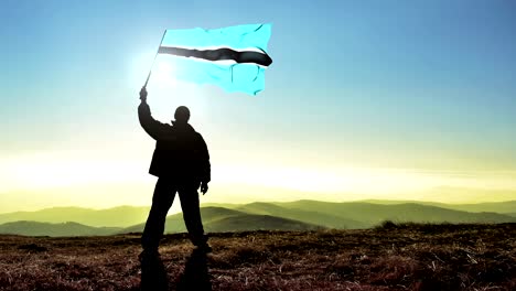 exitoso hombre silueta ganador agitando bandera de botswana en la parte superior del pico de la montaña. fondo de bucle cinemagraph