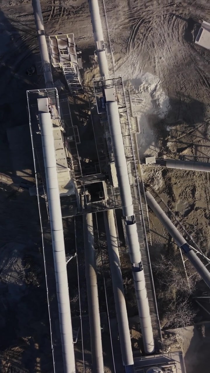 Cantiere di cava con macchinari e materiali in funzione durante il giorno